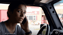 a woman in a car talking on a cell phone with #chicagofire written on the bottom right
