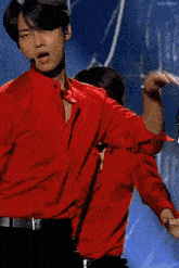a man in a red shirt is dancing with another man in black pants