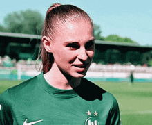 a woman wearing a green nike soccer jersey