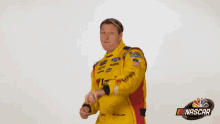 a man in a yellow and red nascar suit is dancing .