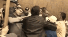 a group of people are fighting in a room with a wooden pole .