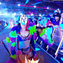 a woman in a colorful outfit stands in front of a crowd with the hashtag #thenextphatman on the bottom right