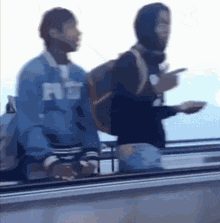 a man wearing a blue sweatshirt with the letter rs on it