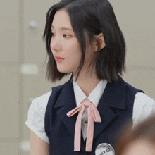 a girl wearing a white shirt and a blue vest has a badge on her neck that says ' i love you '