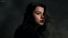 a close up of a woman 's face with red lipstick and a dark background .
