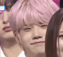 a group of people with pink hair are sitting next to each other and making funny faces .