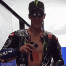 a man wearing a monster hat is holding a bottle