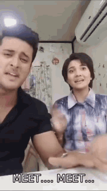 a man and a woman are standing next to each other and the words meet are on the screen