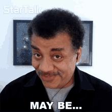a man wearing headphones says may be in front of a picture
