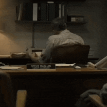 a man sits at a desk with a name tag that says steve raglan career counselor