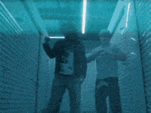 a man walking down a hallway with a sign on the wall that says ' i 'm sorry '