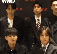 a group of young men pose for a photo in front of a netflix sign