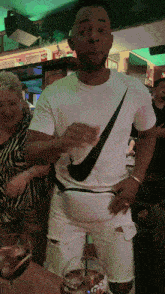 a man wearing a nike t-shirt is holding a drink in his hand