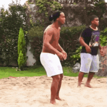 a shirtless man in white shorts is jumping in the air