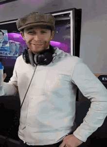 a man wearing headphones and a hat is smiling