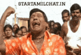 a man in an orange shirt is laughing in front of a crowd with the words starttamilchat.in on the bottom