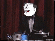 a man in a suit is standing in front of a drum set that says snl week on it