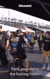 a man in a pennzoil shirt is riding a motorcycle