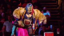 a woman in a fur coat is standing in front of a crowd of people .