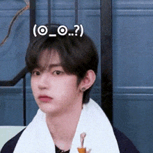 a young man with a towel around his neck is making a face .