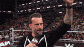 a man in a wrestling ring is holding a microphone that says aww