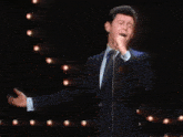 a man in a suit and tie has his arms outstretched