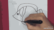 a person is drawing a fish on a piece of paper that says draw cute things on it