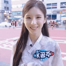 a woman wearing a white shirt with a sticker on it that says k on it