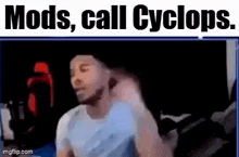 a man is standing in front of a computer screen with the words `` mods , call cyclops '' .