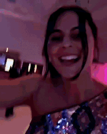a woman in a sequined dress is smiling and laughing