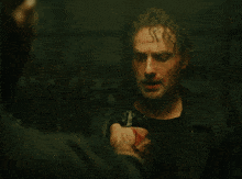 a man with a bloody hand holds a cell phone to his face