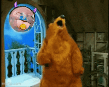 a brown bear is standing in front of a window and a balloon with a face on it