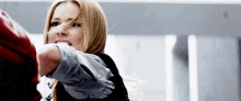 a woman with blonde hair is pointing her finger at someone