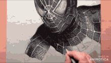 a person is drawing a spider man with a pencil on a piece of paper