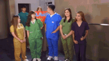 a group of people in scrubs are standing around a man holding a sign that says lamp