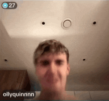 a man without a shirt is making a funny face in front of a camera with the name ollyquinnn on the bottom