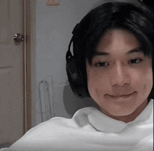 a young man wearing headphones looks at the camera with a smile on his face