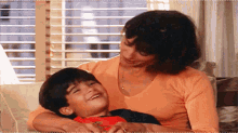 a woman is sitting on a couch with a young boy