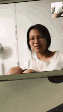 a woman wearing glasses is sitting in front of a fan