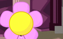 a pink flower with a yellow center is standing in a room .