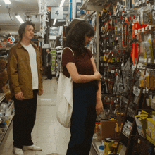a man and a woman are standing in a hardware store with a sign that says 4