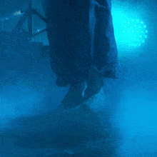 a person 's feet are visible in a dark room with blue lights