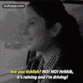 a woman is sitting in a car and smiling while talking to a man .