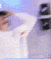 a blurry picture of a person standing in front of a purple wall