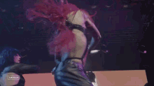 a woman with red hair is dancing on a stage in front of a screen that says cancela