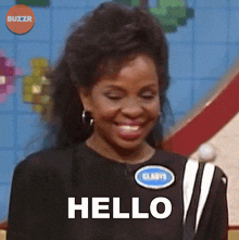 a woman is smiling and saying hello on a game show
