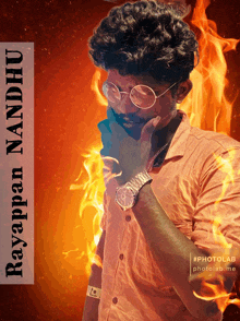 a man wearing glasses and a watch is standing in front of a fire background with the name rayappan nandhu