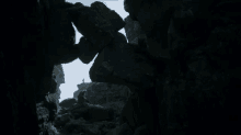 a person is standing in a cave surrounded by rocks