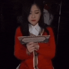 a woman in a red sweater is holding a piece of paper that says employment eligibility on it