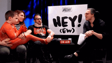 people sitting in front of a sign that says hey